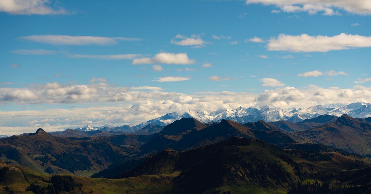 Majestic alpine mountains with snow peaks under a clear blue sky, perfect for travel inspiration.